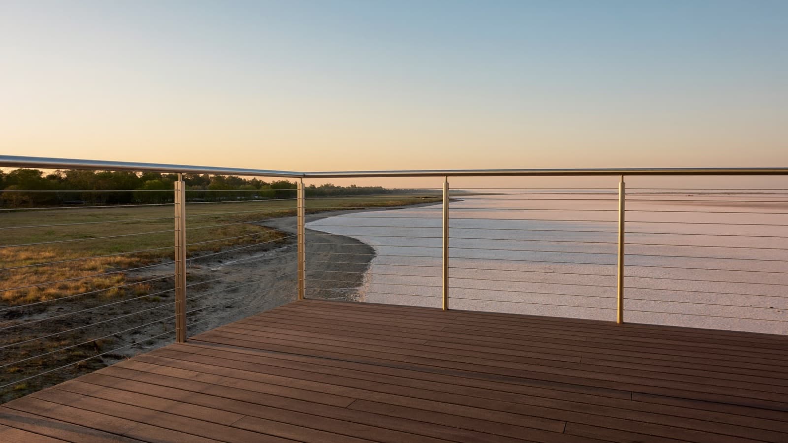 Deck with cable railing overlooking a coastal North Carolina marsh at golden hour