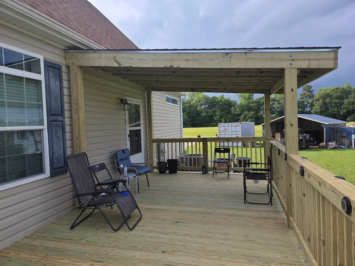 New pressure-treated wood deck with a covered section, railing with post lighting, and seating on a Jacksonville-area home